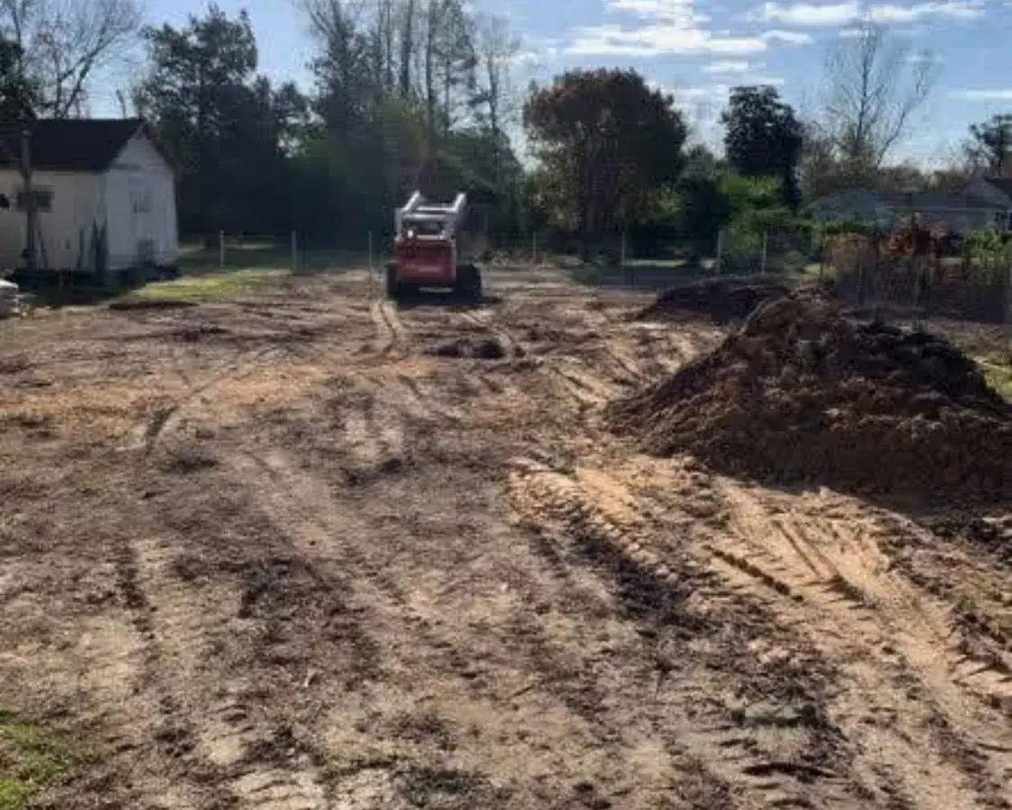 Compact track loader clearing trees and prepping a residential lot in Jacksonville NC