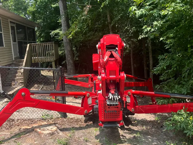 Compact spider lift set up in a tight fenced backyard for tree removal in Jacksonville, NC